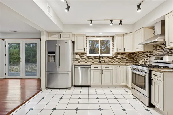 a kitchen with granite countertop a stove a refrigerator and a sink