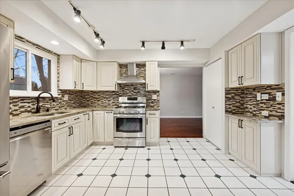 a kitchen with stainless steel appliances a stove sink and cabinets