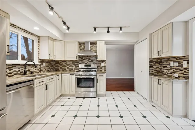a kitchen with stainless steel appliances a stove sink and cabinets