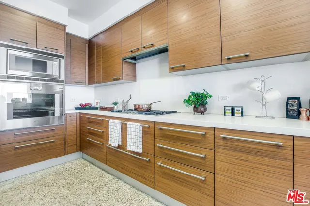 a kitchen with stainless steel appliances granite countertop a sink a stove and cabinets