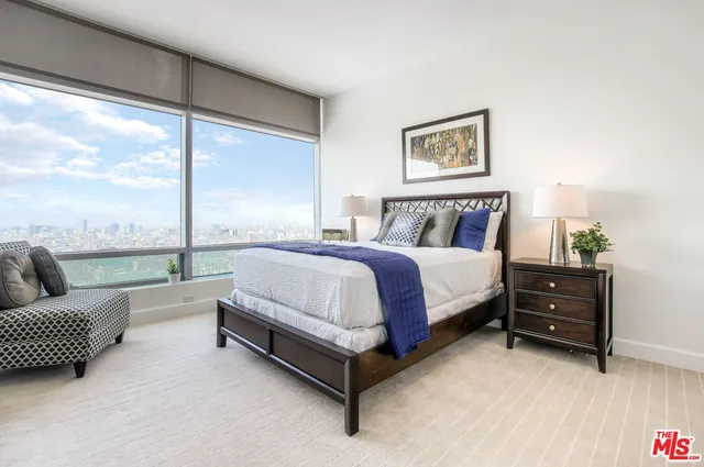 a spacious bedroom with a bed and a large window