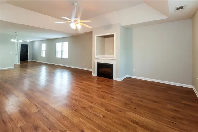 a view of a livingroom with wooden floor and a ceiling fan