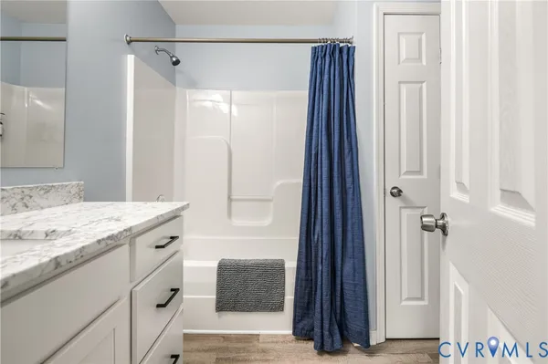 a bathroom with a granite countertop sink a mirror and a shower