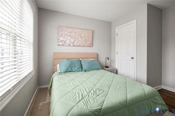 a large bed in a bedroom next to a window