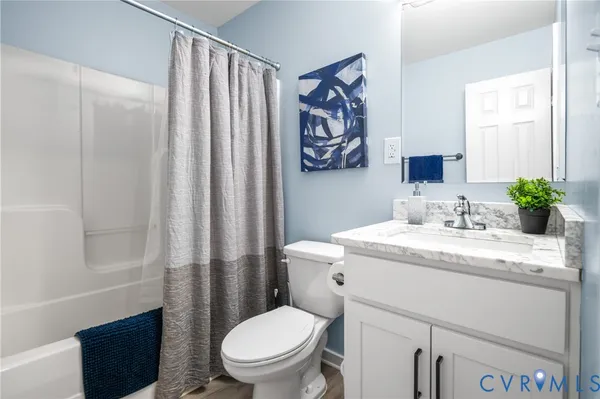 a bathroom with a granite countertop sink toilet and a mirror