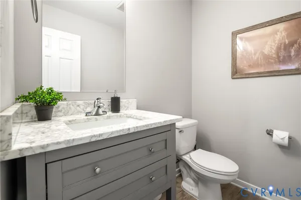 a bathroom with a granite countertop toilet sink and mirror