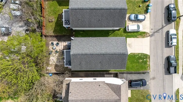 an aerial view of a house with a yard potted plants and large tree