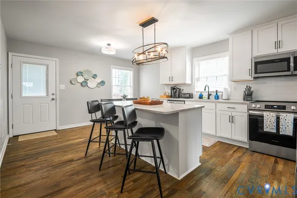 a kitchen with a table chairs stove and cabinets