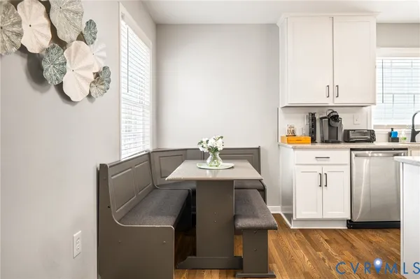 a dining hall with granite countertop white cabinets and refrigerator