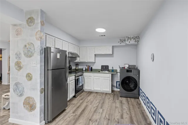 a kitchen with a refrigerator and a stove top oven