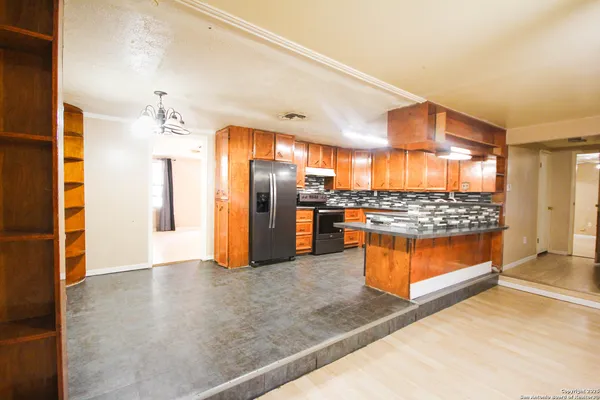 a kitchen with stainless steel appliances kitchen island granite countertop a refrigerator and a stove