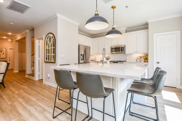 a kitchen with stainless steel appliances kitchen island granite countertop a table and chairs