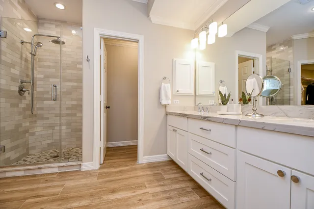 a bathroom with a double vanity sink mirror and shower