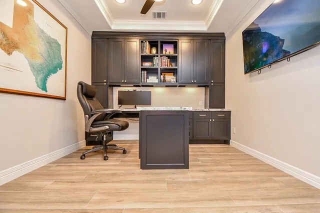 a view of a workspace with furniture and a flat screen tv