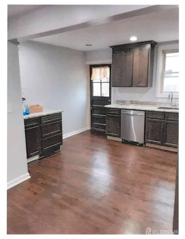 a kitchen with granite countertop a stove a sink and a microwave