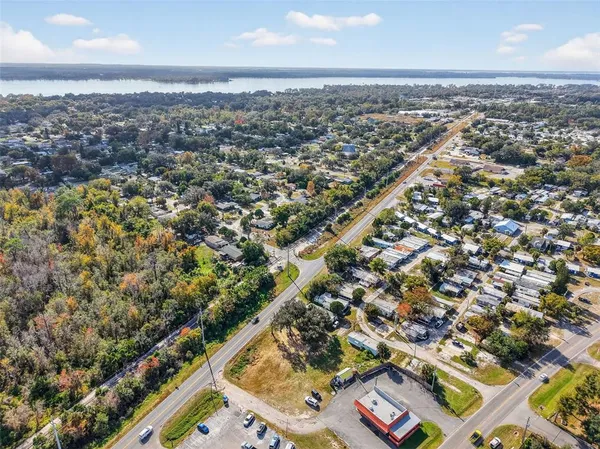 an aerial view of residential houses with outdoor space and lake view
