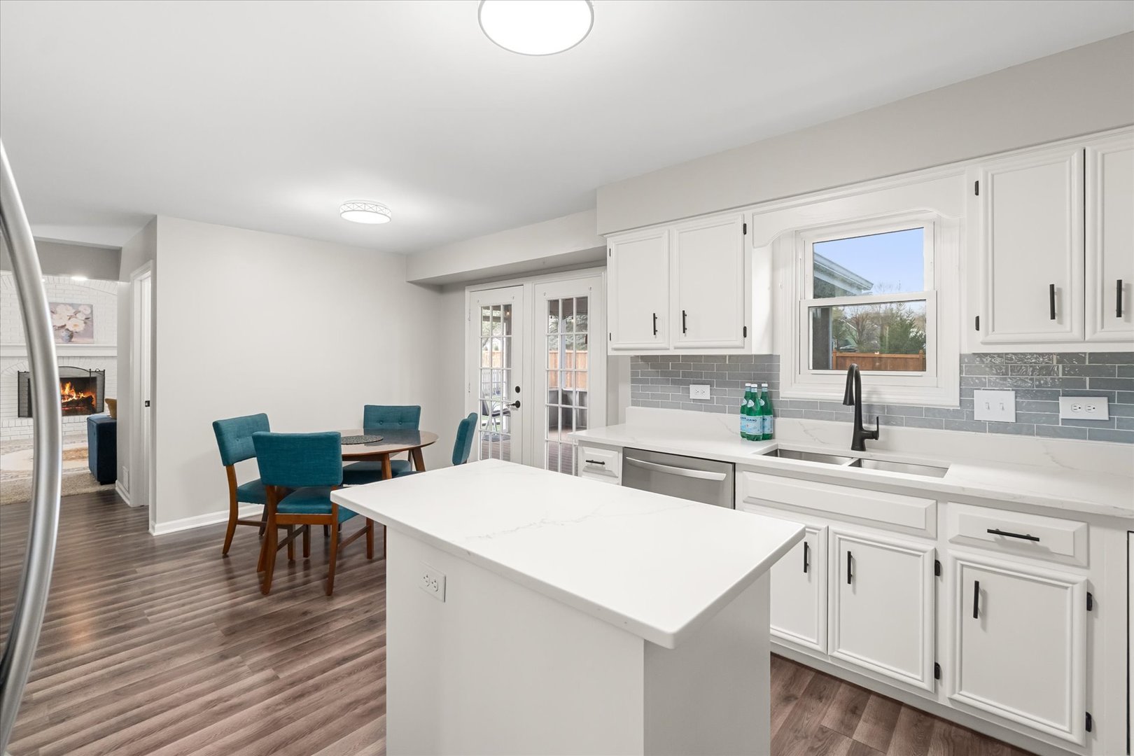 1763 Frost Lane Naperville, IL 60564 - Photo 9 of 46 a kitchen with stainless steel appliances a white table chairs and a wooden floor