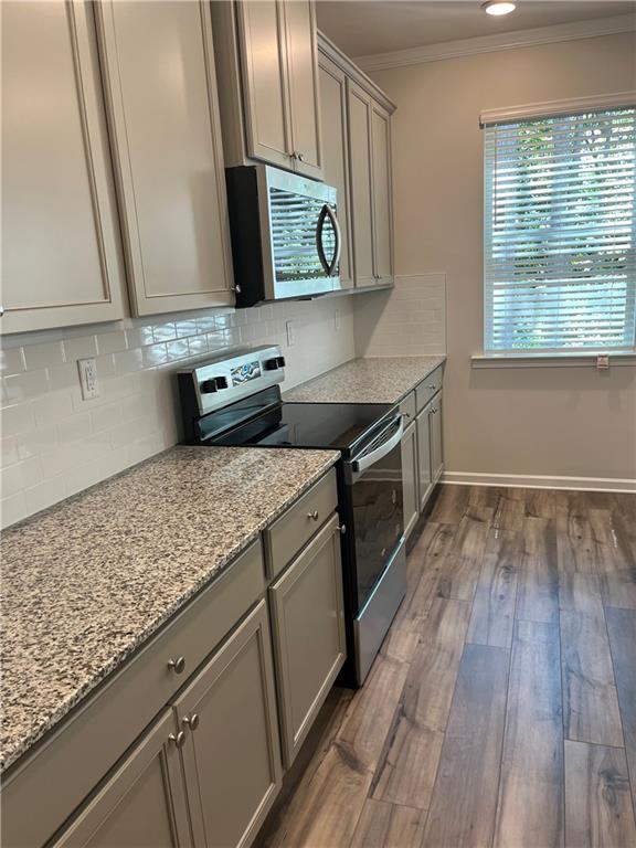 4524 Ajo Walk Atlanta, GA 30331 - Photo 14 of 40 a kitchen with stainless steel appliances granite countertop a stove and a wooden floors