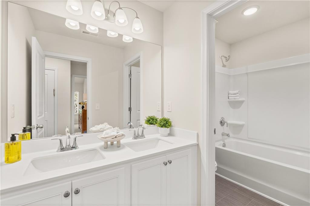 4524 Ajo Walk Atlanta, GA 30331 - Photo 8 of 40 a bathroom with a sink a large mirror and a bathtub