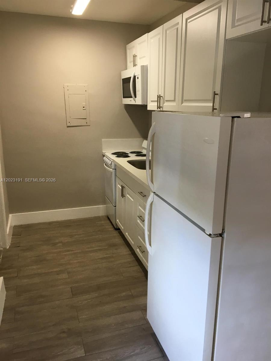 520 Southwest 4th Street, Unit 5 Miami, FL 33130 - Photo 7 of 11 a kitchen with a refrigerator stove and cabinets