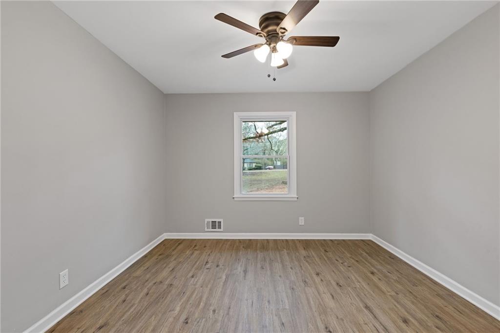 2224 Hudson Drive Southwest Lilburn, GA 30047 - Photo 14 of 31 wooden floor in an empty room with a window