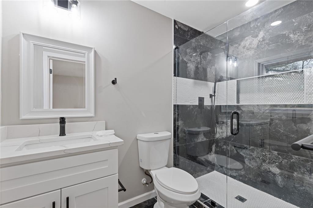 2224 Hudson Drive Southwest Lilburn, GA 30047 - Photo 16 of 31 a bathroom with a sink a toilet and shower