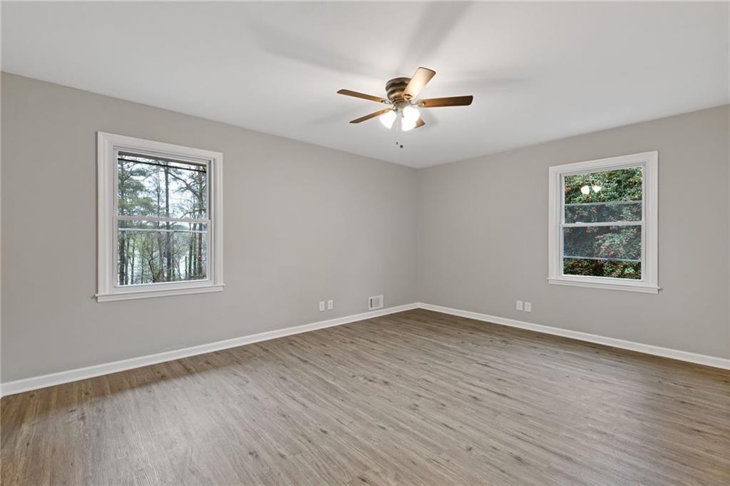 2224 Hudson Drive Southwest Lilburn, GA 30047 - Photo 17 of 31 a view of an empty room with wooden floor and a window