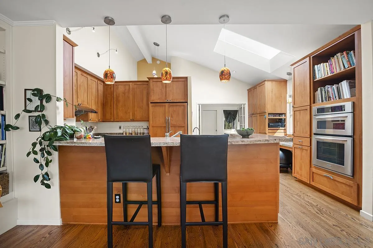 a dining room with stainless steel appliances kitchen island granite countertop a table chairs and a refrigerator