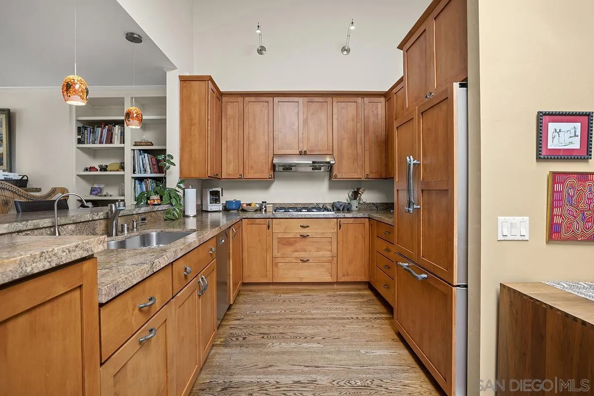 4329 Arista Street San Diego, CA 92103 - Photo 16 of 44 a large kitchen with stainless steel appliances granite countertop a refrigerator a sink dishwasher a stove with wooden cabinets