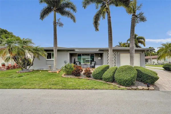 a front view of a house with a garden and yard