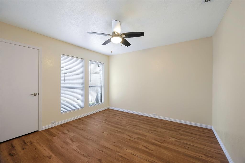 6512 Mc Cormick Ranch Court Plano, TX 75023 - Photo 18 of 29 an empty room with wooden floor fan and windows