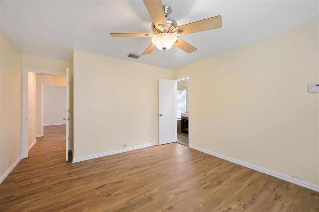 6512 Mc Cormick Ranch Court Plano, TX 75023 - Photo 23 of 29 an empty room with wooden floor fan and windows
