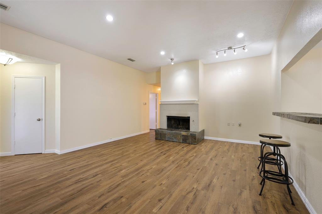 6512 Mc Cormick Ranch Court Plano, TX 75023 - Photo 9 of 29 a view of empty room with wooden floor and fireplace