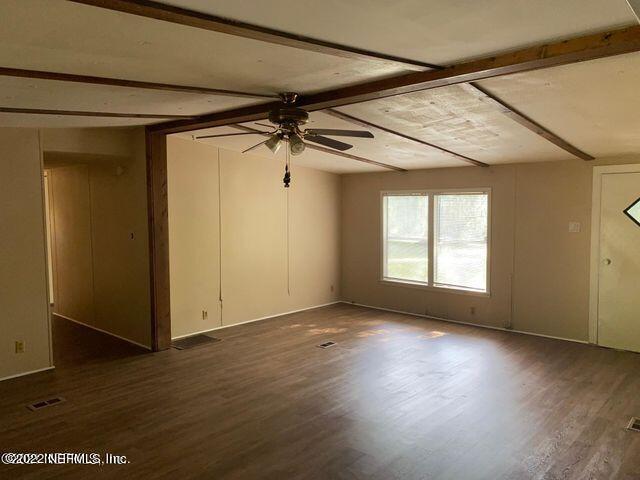 2955 Hilltop Road St. Augustine, FL 32086 - Photo 2 of 9 an empty room with wooden floor and windows