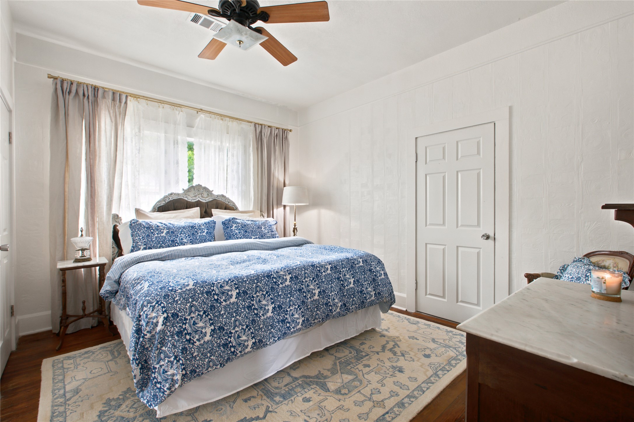 372 Old Lockhart Road Lockhart, TX 78644 - Photo 19 of 40 Well-lit primary bedroom features rich wood flooring and a classic ceiling fan for optimal comfort.