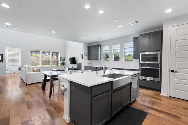 a large kitchen with a large counter top sink appliances and living room