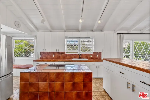 a kitchen with sink a window and cabinets