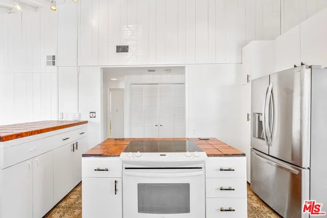 a kitchen with white cabinets and white appliances