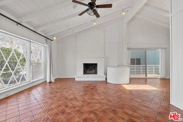 a view of an empty room with a fireplace and a window