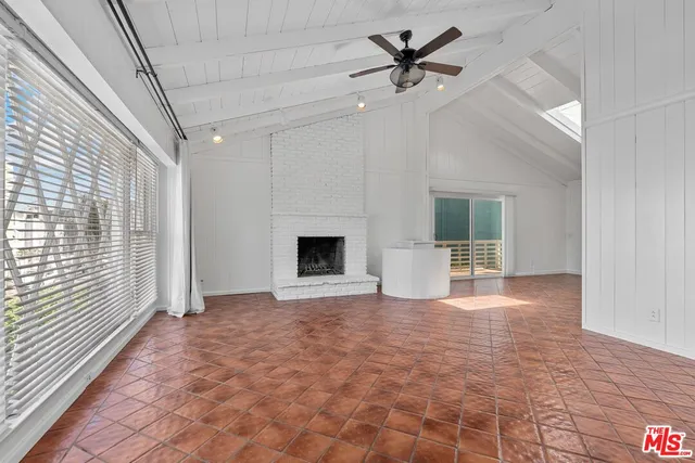 a view of an empty room with a fireplace and a window