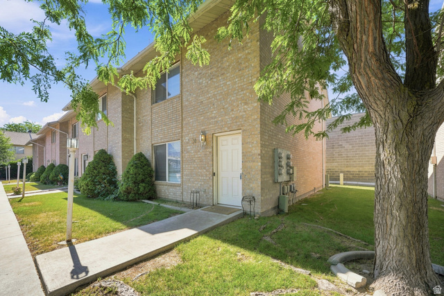 203 North Geneva Road, Unit 10 Provo, UT 84601 - Photo 17 of 30 Multi-story brick building exterior with a white entry door, exterior lighting, and foundation landscaping