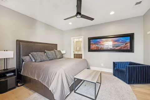 a bedroom with a bed a couch and a chandelier