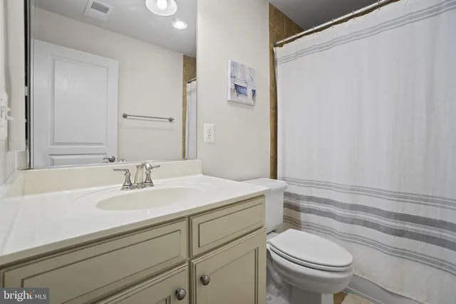a bathroom with a sink toilet vanity and tub