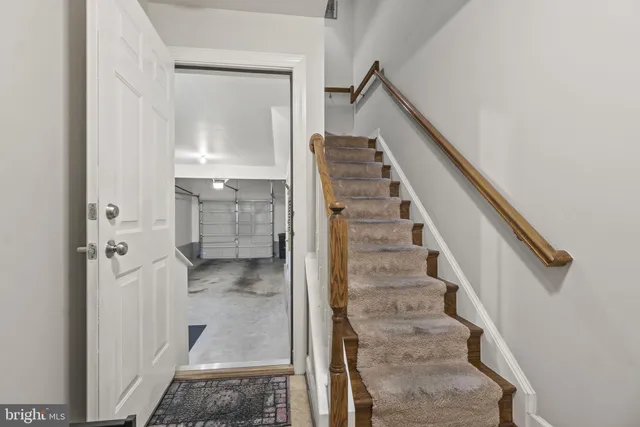 a view of staircase with white walls and utility room