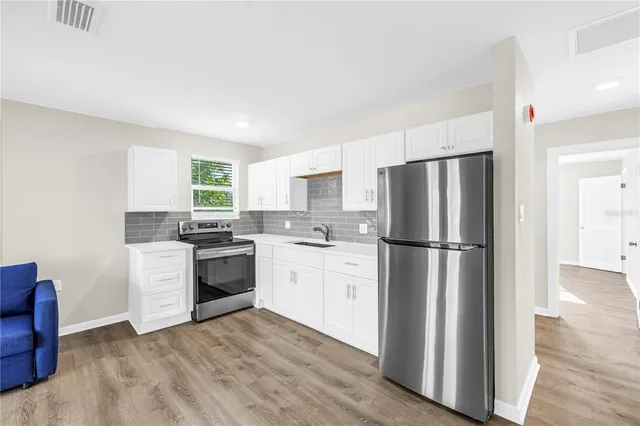 a kitchen with a sink a refrigerator a stove and cabinets