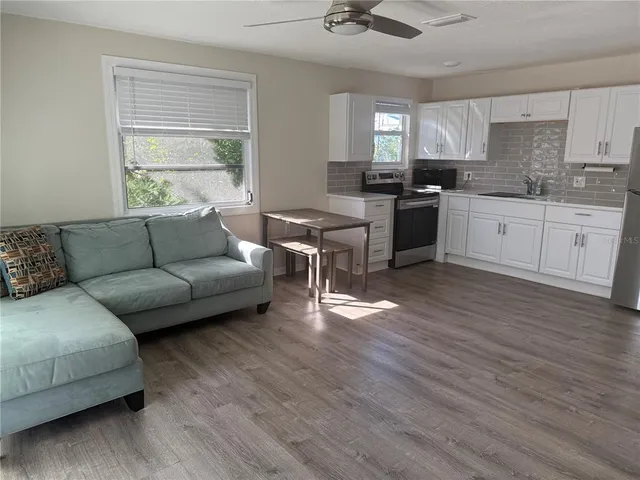 a living room with furniture and a wooden floor