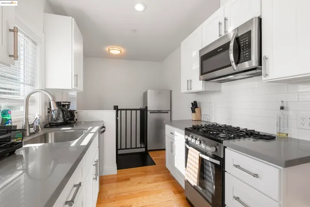 a kitchen with stainless steel appliances granite countertop a stove a sink and a microwave