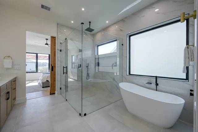 a spacious bathroom with a tub sink shower and mirror