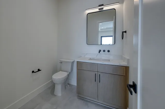 a bathroom with a toilet sink and mirror