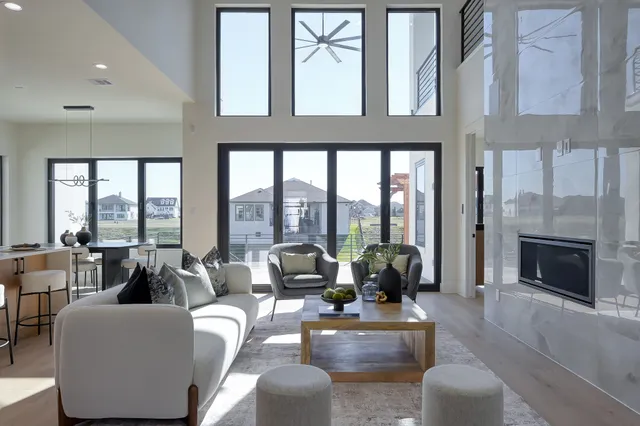 a living room with furniture fireplace and floor to ceiling windows